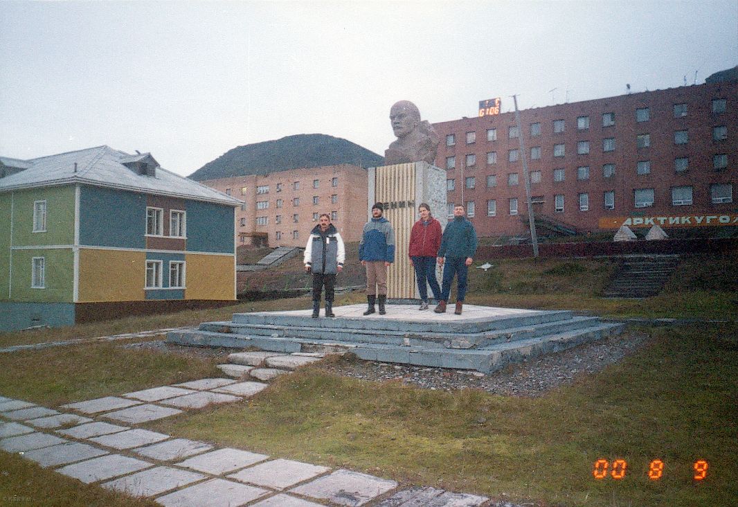 4 osoby stoją obok pomniku Lenina